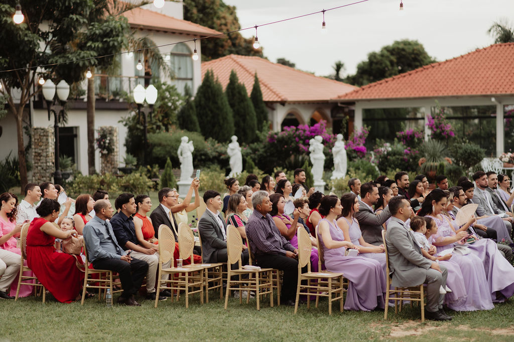 Convidados assistindo à cerimônia de casamento em um jardim