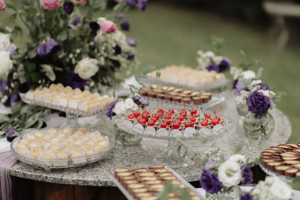 Mesa de doces com decoração em tons de roxo e branco